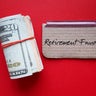 Dollars cash money and paper note with text written RETIREMENT FUND on copy space background - concept of financial planning saving money goal on purpose of retirement security 