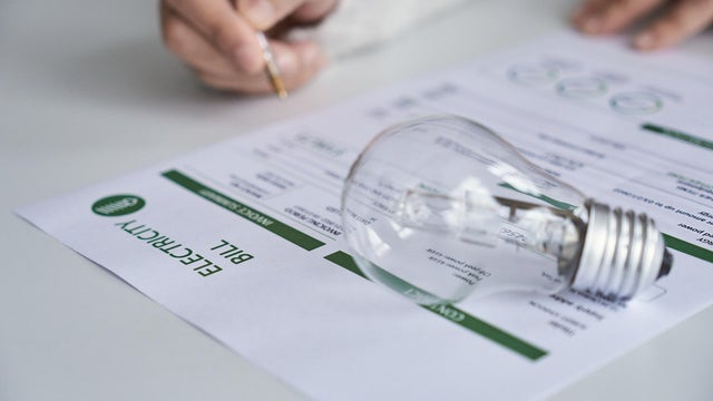 Close up view of a person checking electricity bill at home. 