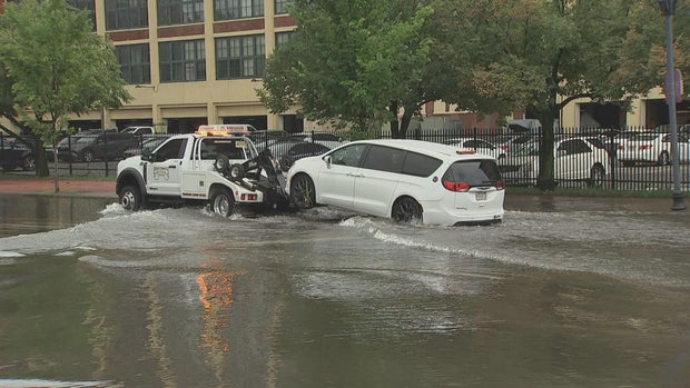 A minivan is towed away from floodwaters in Camden 
