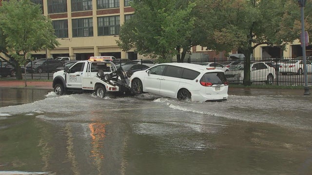 A minivan is towed away from floodwaters in Camden 