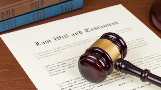 Last will and testament with wooden judge gavel; document is mock-up not real 