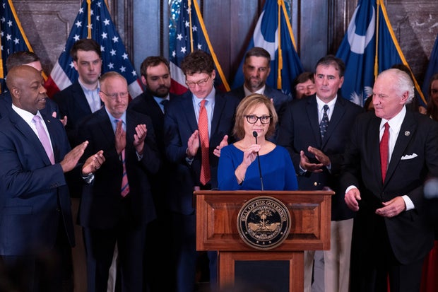 Darline Graham Nordone, with South Carolina Gov. Henry McMaster, right, and Sen. Tim Scott, left, speaks on July 13, 2026, in South Carolina after being appointed to fill the vacancy created by the death of her brother, Sen. Lindsey Graham.