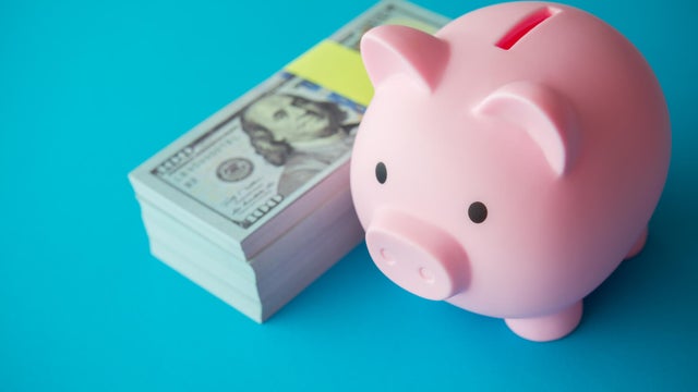 Pink piggy bank and stack US dollar bill banknotes. 