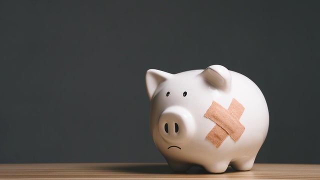 Broken piggy bank with band aid bandage or plaster in finance background concept for economic recession, depression or bankruptcy 