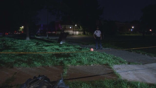 A police officer, crime tape and a basketball are seen near the scene of a shooting in Southwest Philadelphia 