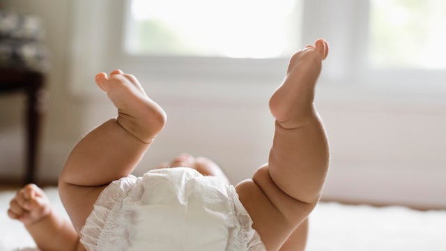 Mixed race baby girl laying on floor 