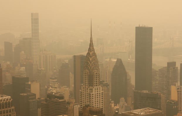 Kanada'daki orman yangınlarından çıkan duman, New York City'de 15 Temmuz 2026'da gün batımından önce Empire State Binası'nın 86. katındaki gözlem güvertesinden görülen kuzey Manhattan şehir merkezi ve Chrysler Binası'nın manzarasını kaplıyor. 