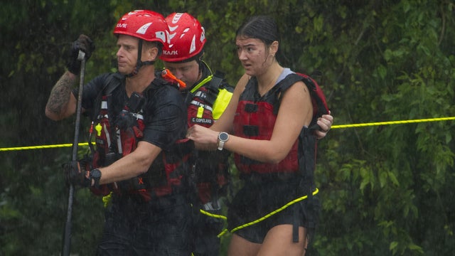 Members of the Boerne Fire Department rescue a woman from floodwaters July 15, 2026, in Boerne, Texas. 
