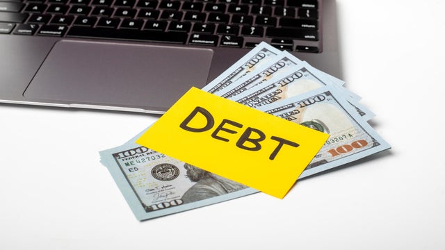 Financial debt management discussion with cash on a desk and a laptop for budgeting and planning 