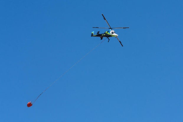 A Kaman K-Max K-1200 heavy-lift firefighting helicopter carrying a helibucket to drop water on a wildfire in Utah..
