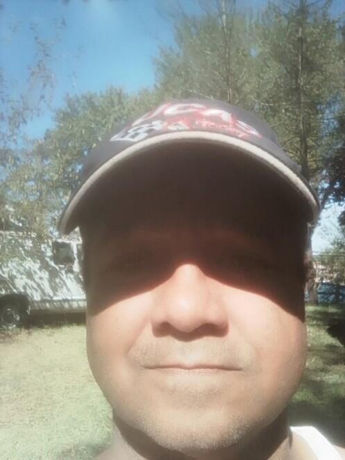 A photo of Rosa with a clean-shaven face and wearing a hat