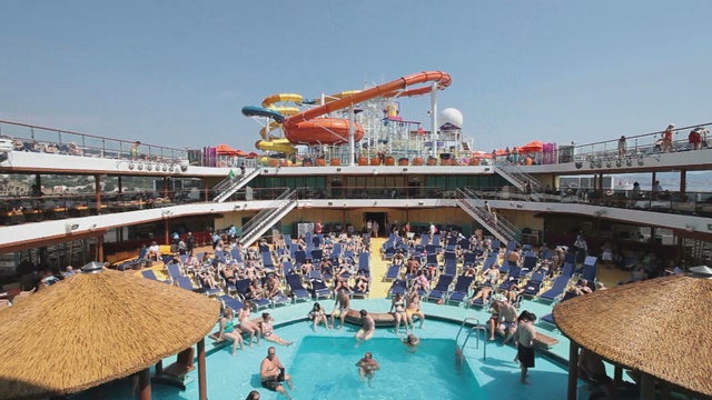 People play and relax in a pool on a cruise ship 