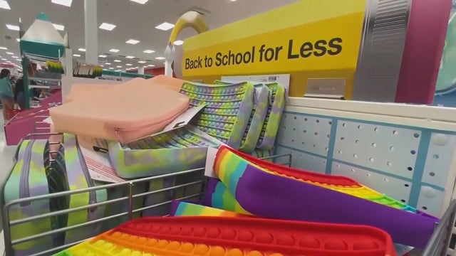 A sign by some pencil cases under a sign that says back to school for less 