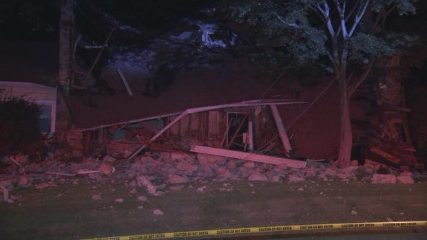 A photo shot at night shows caution tape in front of a house that collapsed in Wynnefield
