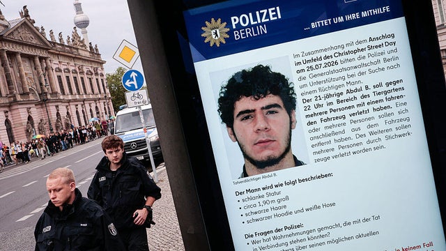 A public information screen displays a Berlin police appeal 