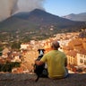 A man and his dog look at a wildfire in a mountain in Onda 