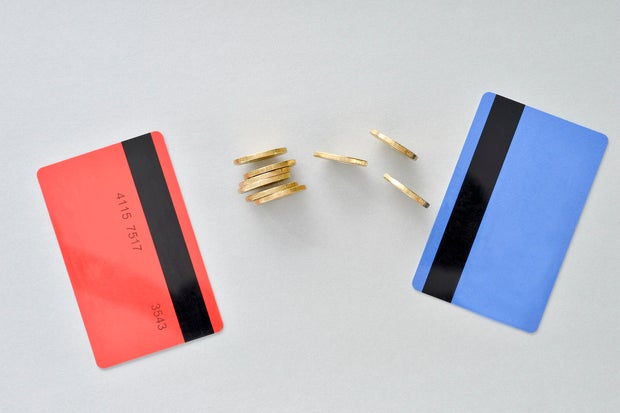 Bank cards are in the colors of living coral and blue with shiny yellow coins symbolizing the electronic exchange of money
