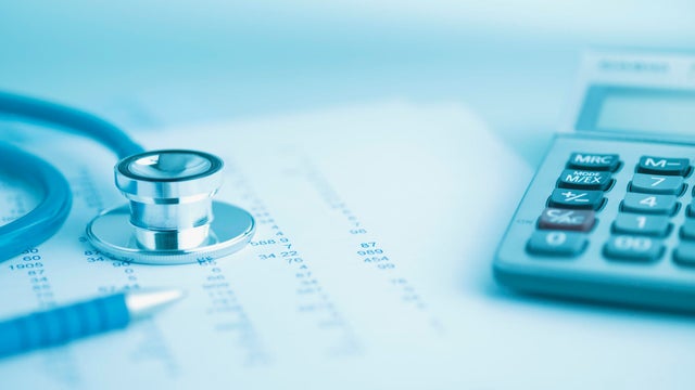 Close up of calculator, data and stethoscope 