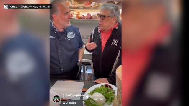 Vincent Pastore speaks with a chef in a deli 