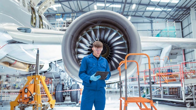 Apprentice aircraft maintenance engineer in maintenance hangar 