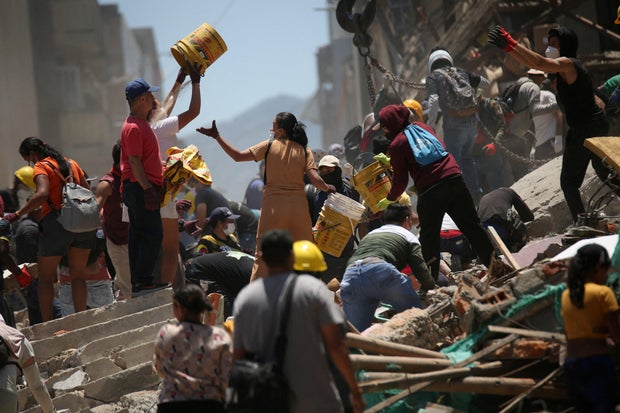 People dig through rubble at the site of a damaged building following an earthquake in Pereira, Colombia, Aug. 11, 2026.