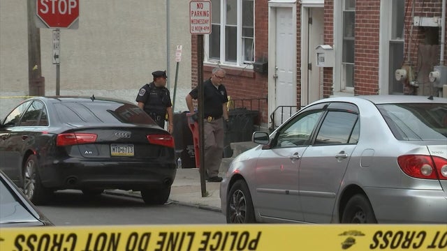 Police tape and officers are seen on a residential block in Norristown after a shooting 