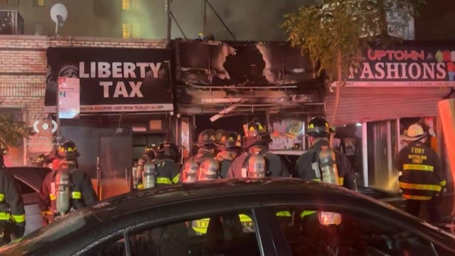 Firefighters outside fire-damaged business 