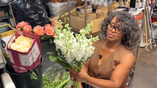 Alisha Simone Bell looks at flowers in her shop 