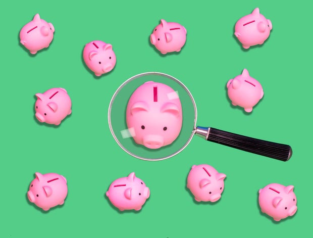 Saving scrutiny - Piggy bank under magnifying glass