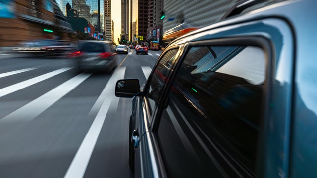 Car Driving Through City - Driver Side Rear View 