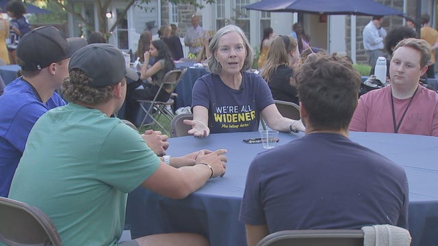 Widener's president speaks with students at an event at her home 