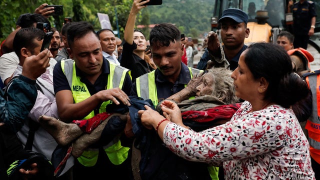 Police officers carry a survivor to a safer place following a flash flood at Trishuli, Nepal 
