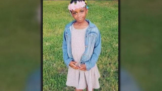 A photo of Fanta Bility, she's wearing a pink dress and denim jacket and a flower crown 