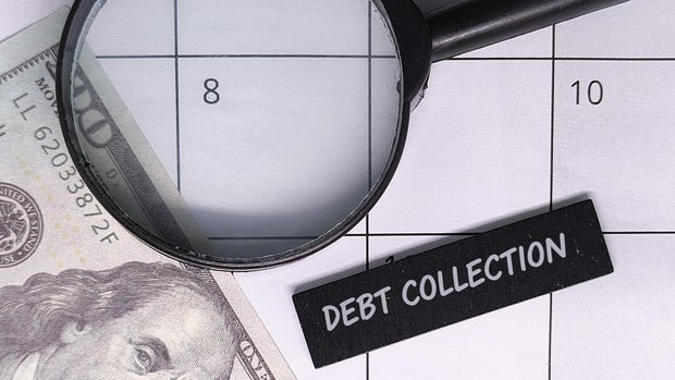 Debt collection concept with money, calendar, and magnifying glass.
