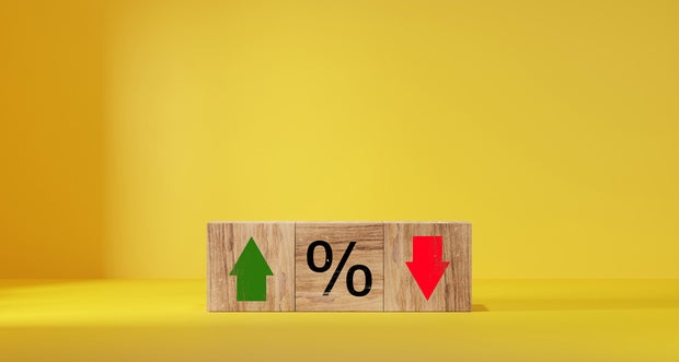 Interest rate financial and mortgage rates concept. Wooden cube block with icon percentage symbol and arrow up and down direction