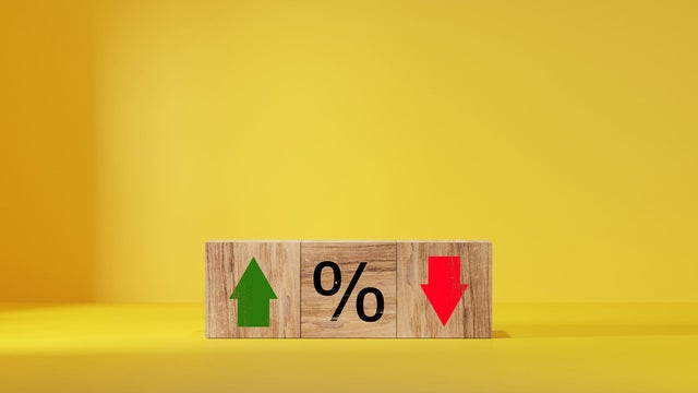 Interest rate financial and mortgage rates concept. Wooden cube block with icon percentage symbol and arrow up and down direction 
