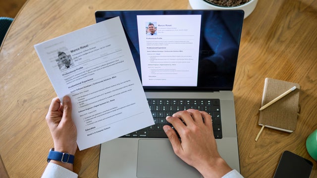 Man digitizing his resume, converting paper CV into a digital format 
