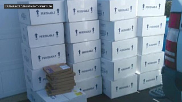 At least 21 boxes marked "perishable" sitting in front of a garage 