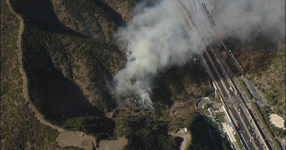 Los Angeles firefighters battle brush fire burning near Getty Center