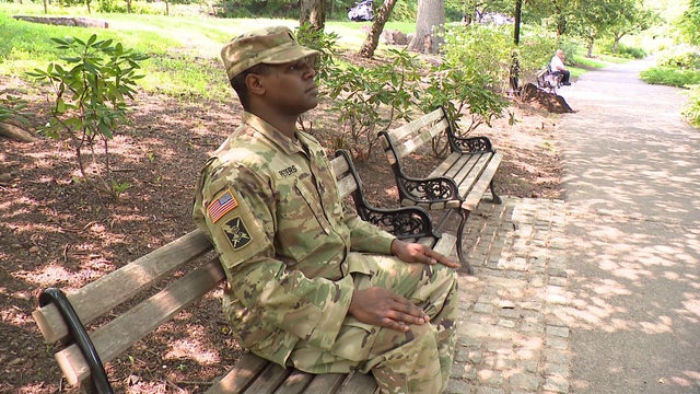 1st Lt. Tawheed Peters sitting on a bench in a park 