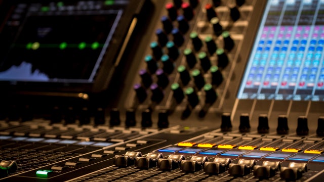 closeup of Professional Digital Audio Sound Mixing Control Console. Silver White Faders and black Graphic control Console, touchscreen control and digital encoders 