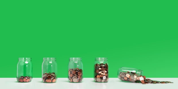 Savings fail - Financial growth with spilling coin jar