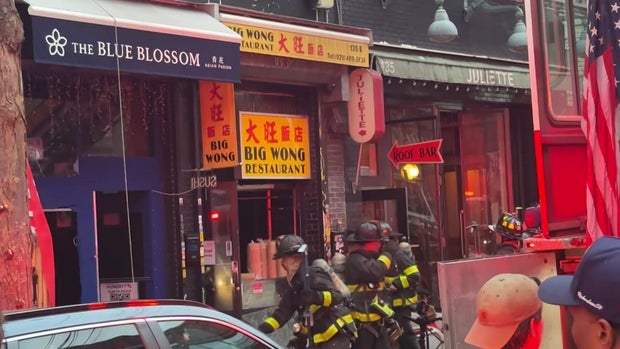 Exterior of three restaurants and firefighters