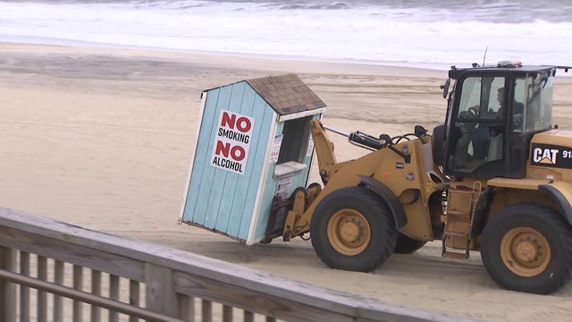 Bulldozer moving a kiosk on a beach 