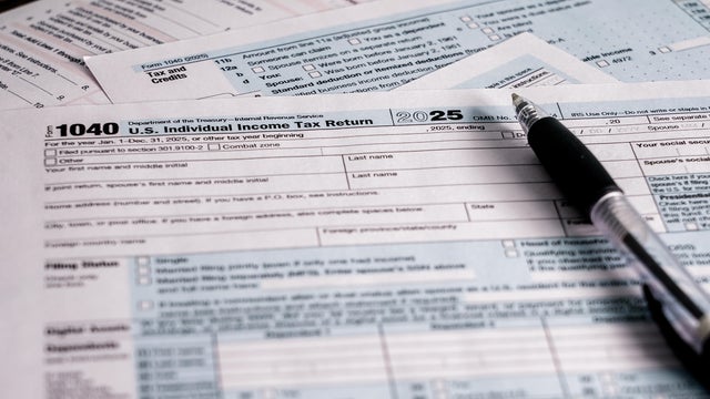 Completing U.S. individual income tax return for the year 2025 with documents and pen on a table 
