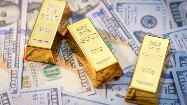Gold bars laying on United States dollars 
