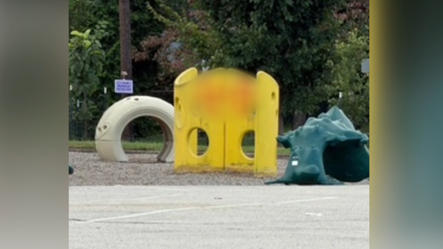 Graffiti on a yellow piece of playground equipment at Weldon playground, the graffiti is blurred 