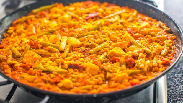 A skillet of colorful traditional Spanish paella cooked and served