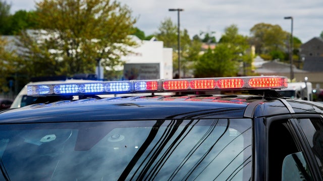 Emergency response vehicle with flashing lights parked during daytime in a city setting 