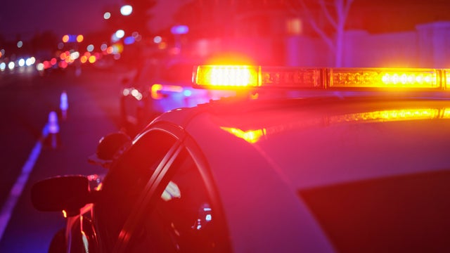 Police Car Stopped on a Road at Night with Emergency Lights 